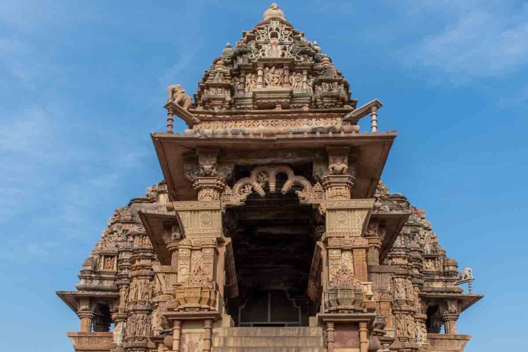 L’ingresso del Tempio Kaṇḍāriyā Mahādeva è imponente e riccamente decorato, tipico dell’architettura templare dell’India medievale. La struttura si presenta come un portale rialzato, raggiungibile tramite una scalinata, che conduce verso l’interno sacro.
