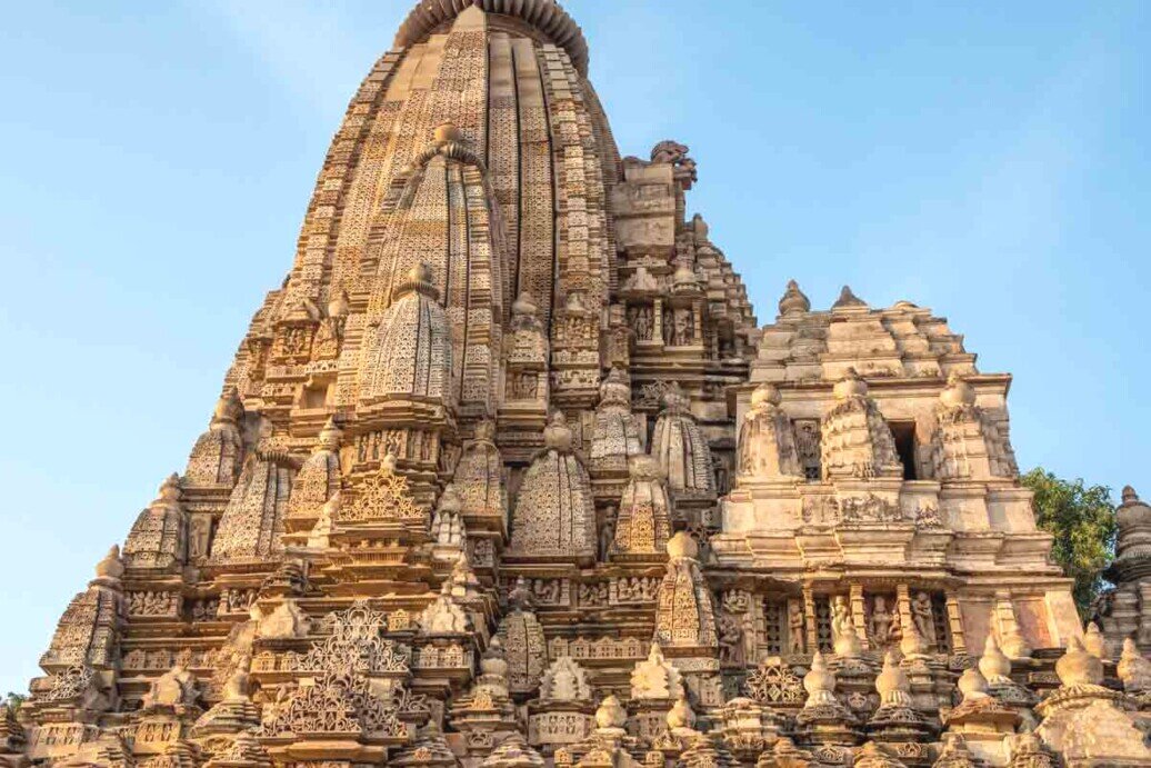 Tempio di Parshwanath a Khajuraho, India: dettaglio della torre centrale con elaborate sculture jainiste, intagli intricati e motivi geometrici, esempio distintivo dell’architettura religiosa dell’epoca Chandela.