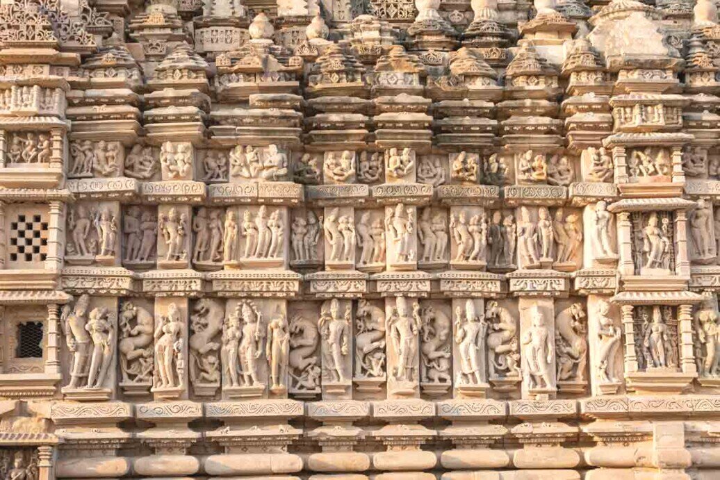 Tempio di Parshwanath, Khajuraho con dettagli nei bassorilievi dove si possono individuare raffigurazioni di animali, scene di caccia e agricoltura, figure umane, simboli astratti e geometrici, ma anche figure mitologiche e leggendarie.
