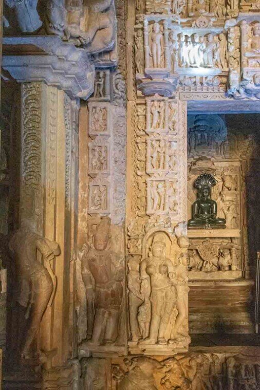 Le colonne interne, elegantemente intagliate, guidano lo sguardo verso l’area centrale o il santuario interno. Sopra l’ingresso o appena oltre, si possono trovare archi decorati con simboli sacri jainisti, come il serpente a più teste (associato a Parshwanath), che rappresenta protezione spirituale.