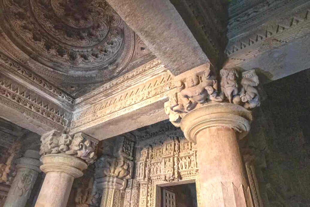Portale finemente scolpito, in pietra chiara. Le superfici sono decorate con motivi geometrici e floreali estremamente dettagliati, simbolo dell’armonia dell’universo secondo la tradizione jainista. Ai lati dell’ingresso compaiono piccole statue o rilievi raffiguranti figure sacre, guardiani simbolici o scene della vita di Parshwanath.