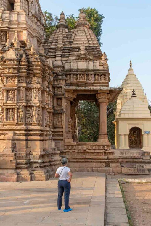 Turista osserva le decorazioni del tempio di Parshwanath a Khajuraho in India.