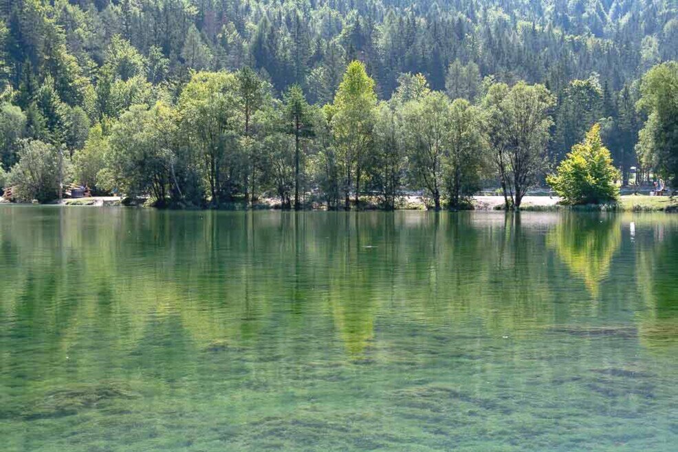 Lago di Jasna riflessi degli alberi intorno sulle acque tranquille del lago di Jasna.