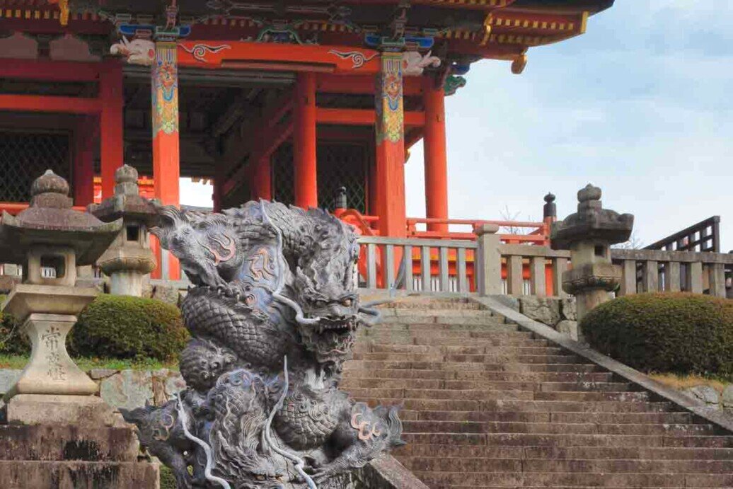 Il cancello Sai-mon, con tetto spiovente. Una scalinata con la statua di un drago a guardia di un edificio in legno ingresso ad un tempio.