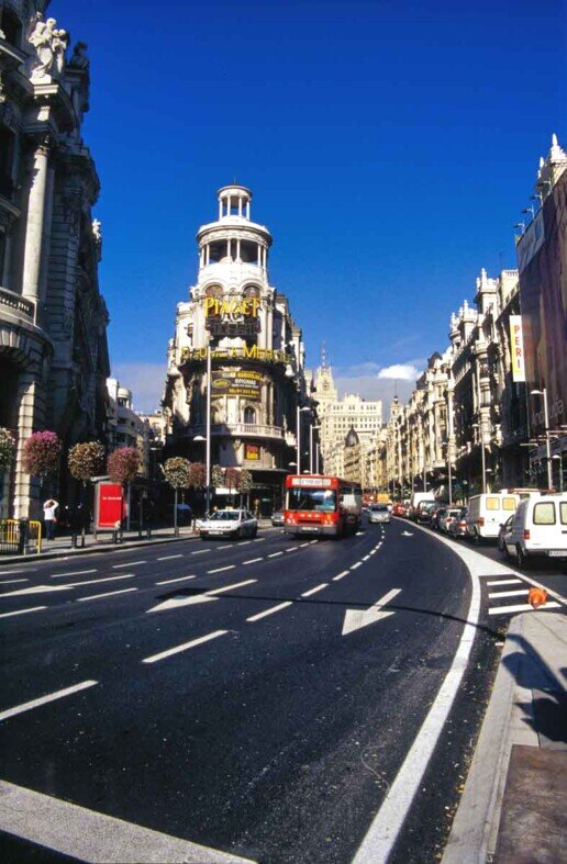 La Gran Vía di Madrid con edifici storici e traffico cittadino.