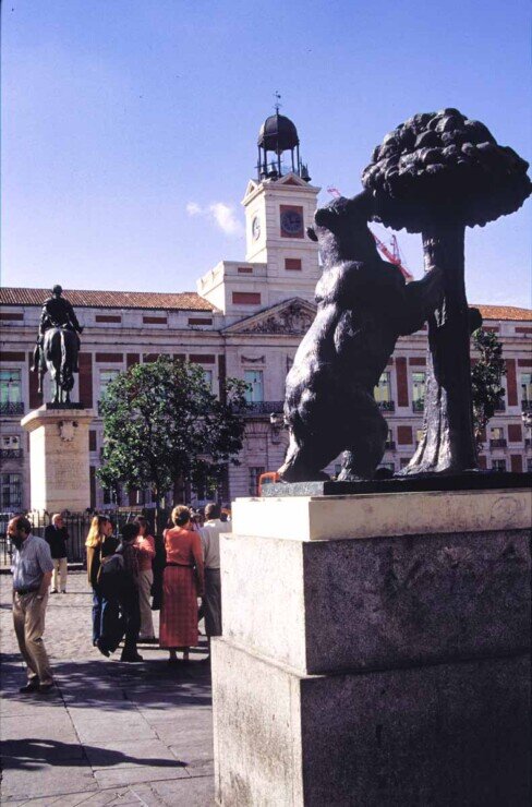 Piazza Puerta del Sol a Madrid, con la statua dell’orso e del corbezzolo in primo piano e gli edifici storici sullo sfondo.