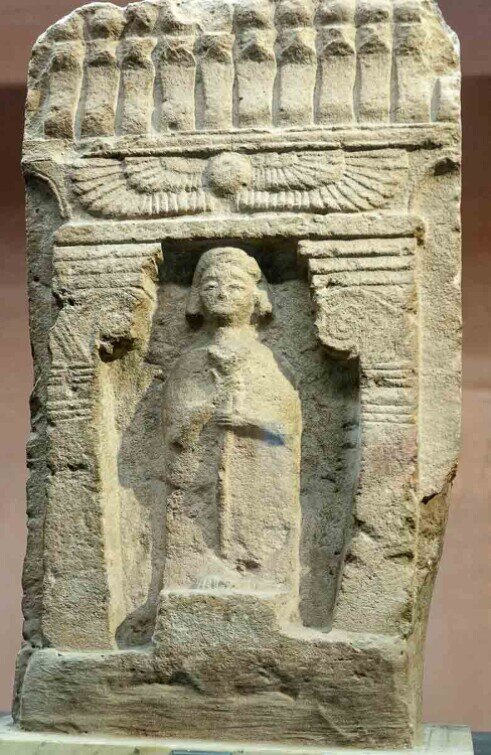 La lastra presenta una figura umana scolpita in rilievo entro una sorta di edicola architettonica, con elementi decorativi di gusto orientale. Le stele sono da considerare come doni votivi agli dei.