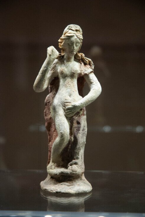 L’immagine raffigura una statuetta votiva femminile in terracotta, di epoca fenicio-punica.