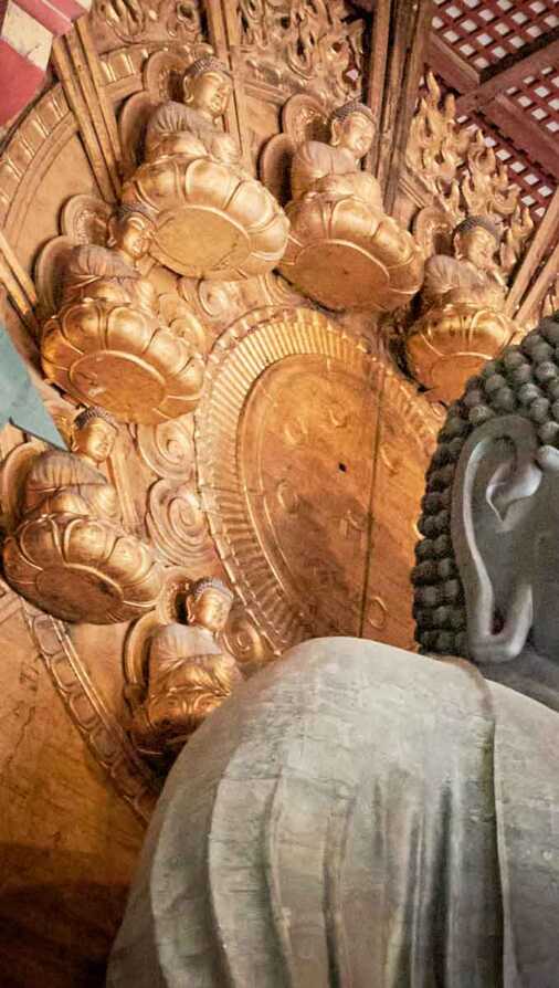 Particolare del Grande Buddah del tempio Todai-ji Sedici statue del Buddha più piccole formano l'aureola intorno al capo del Buddah più grande