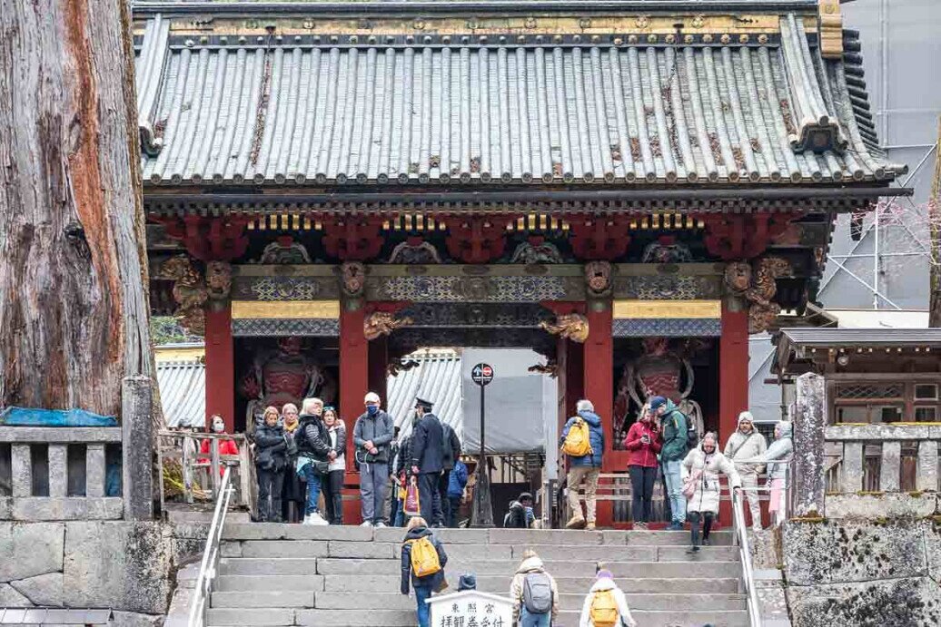 Un gruppo di visitatori si muove attorno alla prima porta del tempio Toshogu a Nikko.