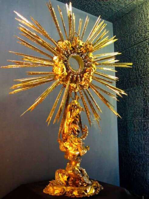 Ostensorio barocco conservato nel tesoro del santuario di Loreto a Praga. Al centro c’è una teca circolare (lunetta) dove viene inserita l’ostia. La struttura intorno è decorata come un sole, simbolo della presenza divina.