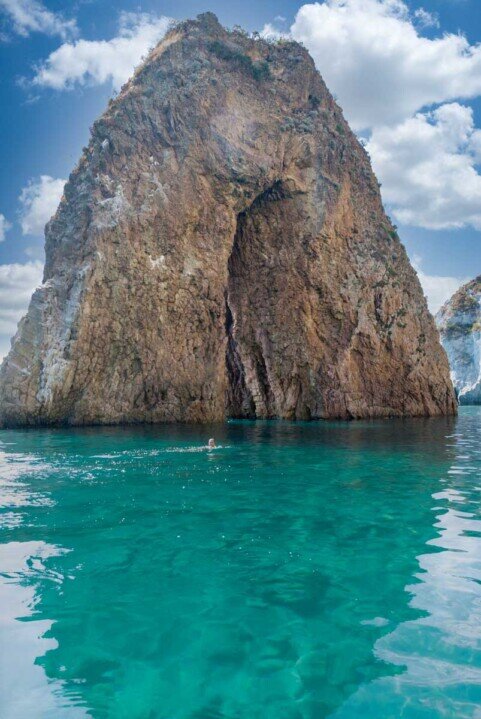 Ponza, arco naturale Un faraglione a forma di arco in un mare verde che ne riflette la forma.
