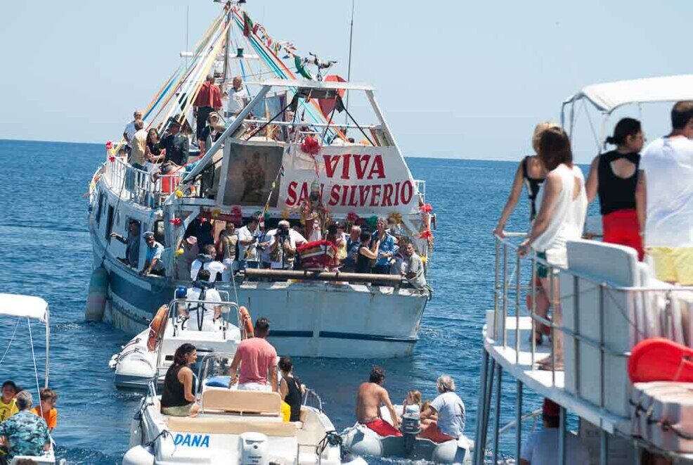 La barca con la statua di San Silverio a bordo, seguita da tante altre barche come in processione.