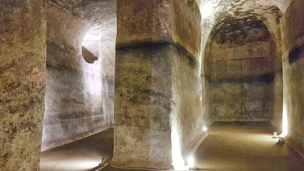 Una antica cisterna romana scavata nel tufo con volte poste su file parallele.