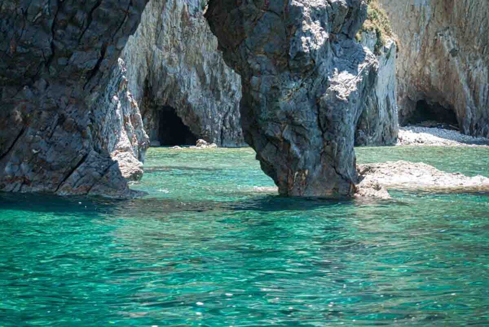 Faraglioni Grotta di Mezzogiorno Faraglioni arguti su un mare smeraldo all'isola di Palmarola