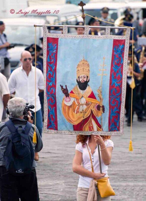 Ragazza in processione che porta lo stendardo con la figura di San Silverio.