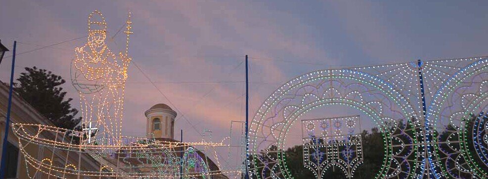Davanti alla chiesa di Ponza luminarie accese a formare una figura di San Silverio a bordo di una barca di pescatori.