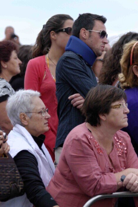Gruppo di persone attendono assorte all'uscita della statua di San Silverio dalla chiesa.