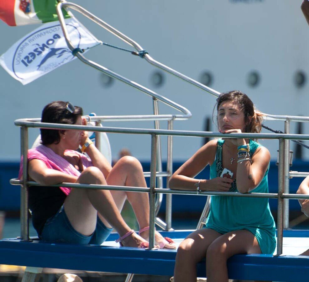 Due ragazze assorte attendono l'uscita della statua di san silverio dalla chiesa per la processione.