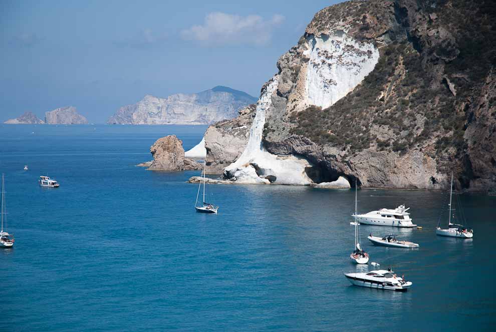 Barche ancorate in acque tranquille, con scogliere e montagne sullo sfondo, Isola di Ponza, Cala di Chiaia di Luna.