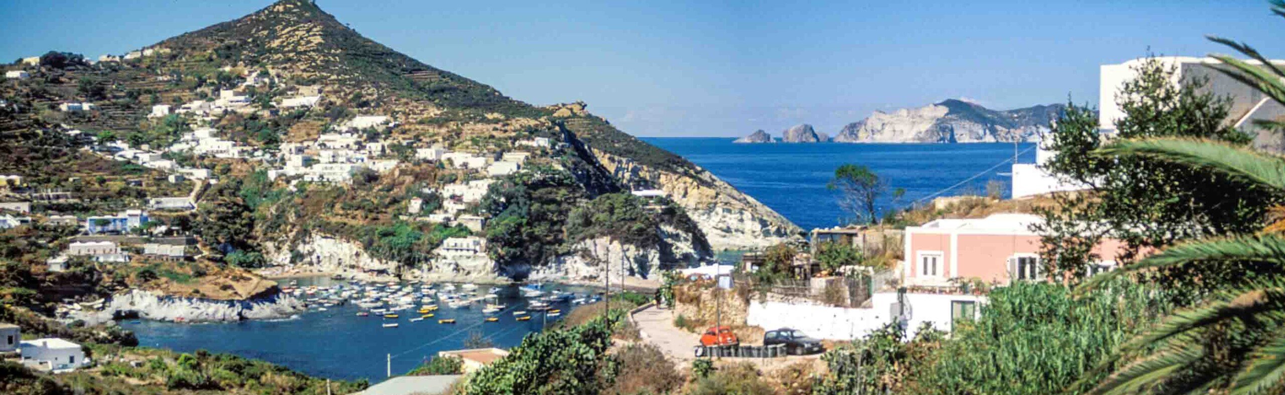 Da Le Forna il panorama di Ponza mostra Cala Feola con le barche di pescatori e sullo sfondo l'isola di Palmarola.