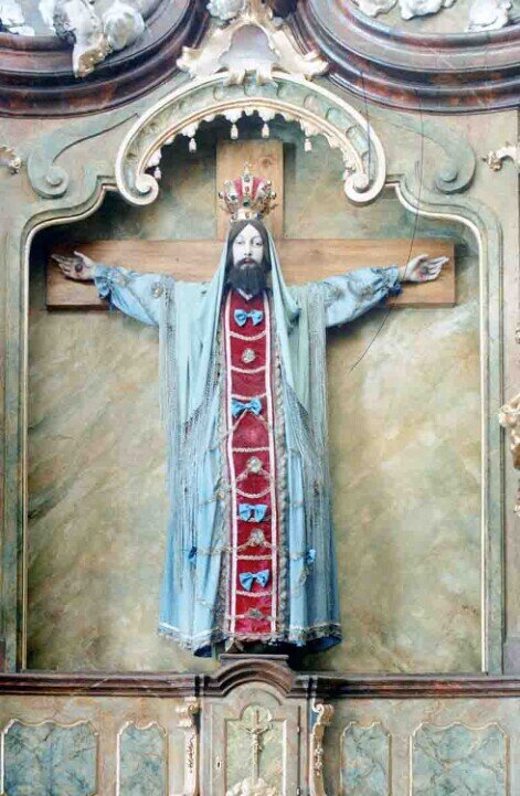 In una nicchia dell'altare, la figura di Gesù Cristo crocefisso che indossa una tunica liturgica colorata. 