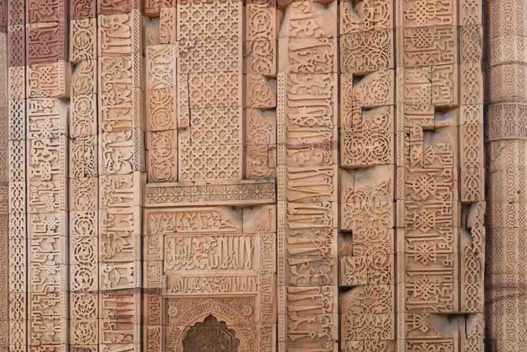 intagli-calligrafia-disegni geometrici del Qutb Minar Una parete completamente ricoperta di intricati intagli, calligrafia e disegni geometrici.