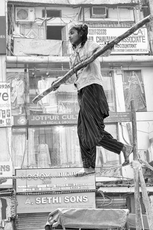 Ragazza, artista di strada, cammina in equilibrio sulla fune.