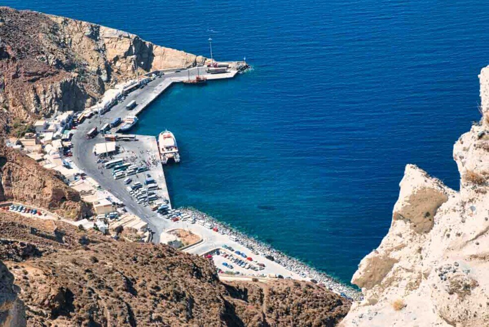 Il porto di Athinios di Santorini visto dall'alto da dove partono le teleferiche e iniziano i gradini che portano fino in cima.