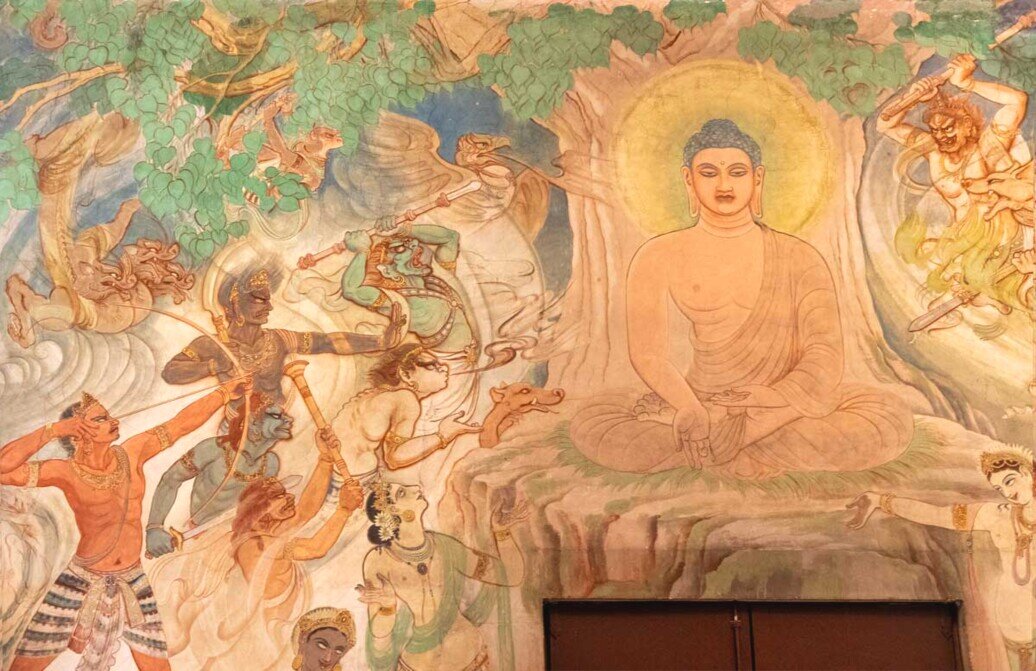 Muro affrescato nel Mulgandha Kuti Vihar, raffigurante Buddha tranquillo e sereno mentre altre figure malvagie lanciano dardi e lance contro di lui.