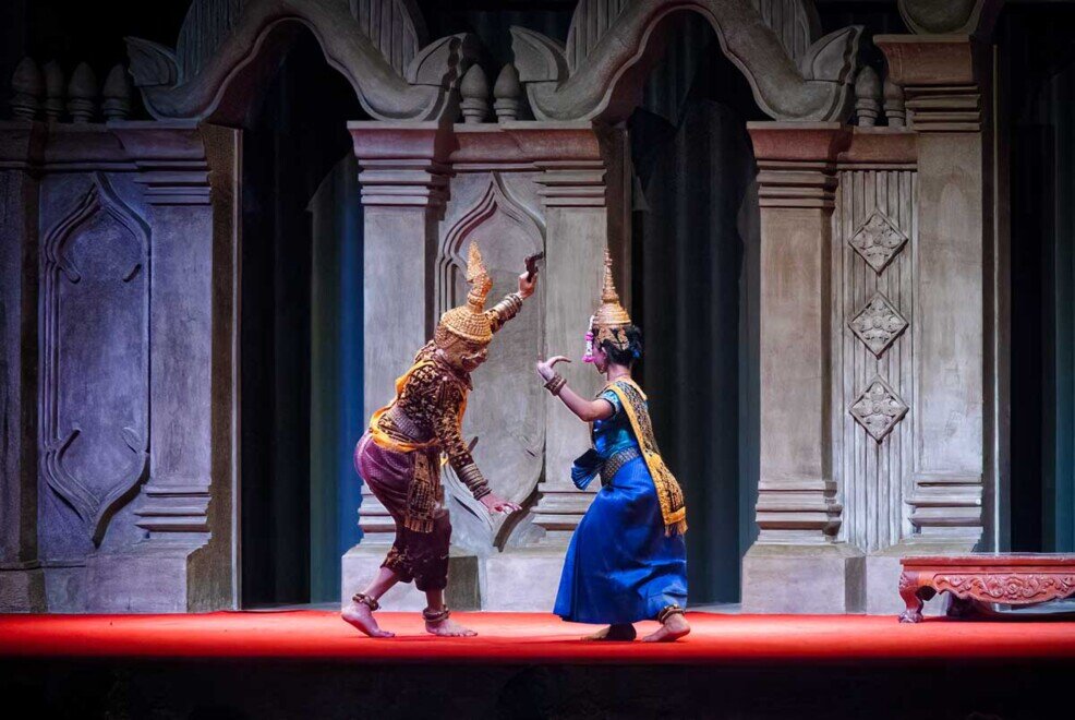 Un uomo travestito col costume che rappresenta il maligno lotta con le armi contro l'apsara.