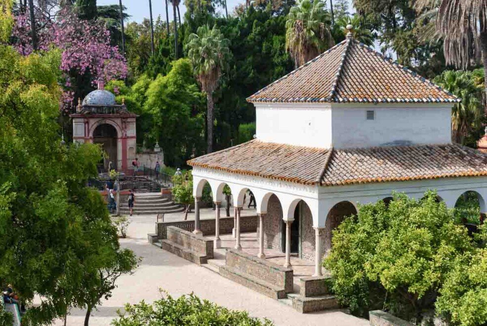 Il Giardino dei Commensali con il Padiglione di Carlo V Un grande padiglione con ampie arcate al centro di un giardino con tanti alberi.