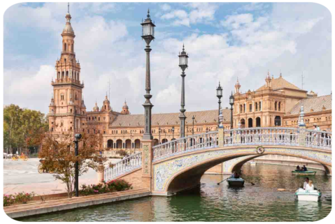 Un fiume artificiale attraversato da piccole barche a remi-un ponte-antiche colonne e porticati.