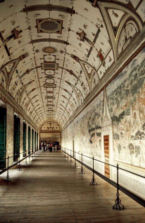Interno della Sala delle Battaglie del Monastero di San Lorenzo de El Escorial: una lunga galleria rinascimentale con volta alta, illuminata lateralmente da finestre, le pareti interamente decorate da grandi affreschi che rappresentano scene di battaglie storiche. 