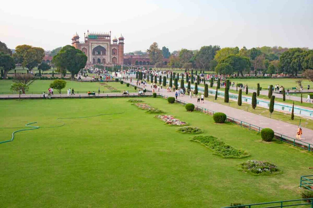 Il Taj Mahal è circondato da un grande giardino in stile persiano, chiamato Charbagh, ed è diviso in quattro sezioni da canali d'acqua e sentieri simmetrici, e comprende anche fontane e vasche che, a seconda della luce, riflettono la magnificenza del mausoleo.