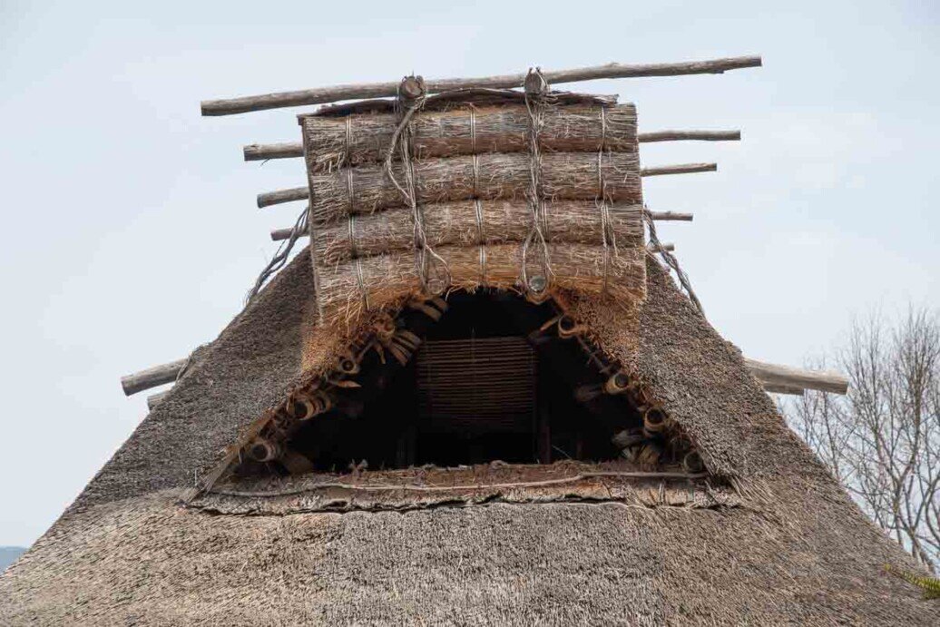 Hida Folk Village sottotetto di una casa Hida Folk Village-Sottotetto di una casa agricola vista dall'esterno che ha un'ampia apertura chiudibile con quattro legni legati uno sull'altro che si abbassano o si alzano in verticale come una persiana.