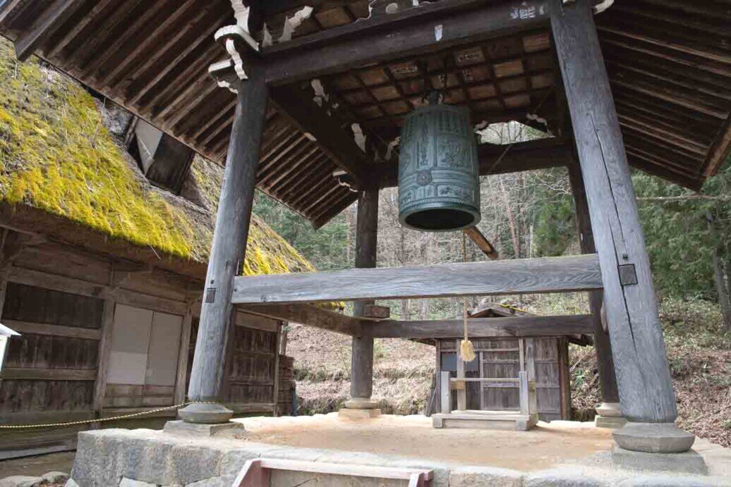 Hida Folk Village campana buddista senza batacchio Piedistallo in pietra con grossi sostegni in legno per tenere sospesa una campana buddista senza batacchio.