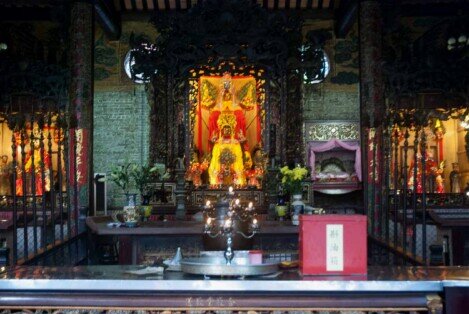 Altare decorato con statue, fiori e candelabri all’interno del tempio di Chợ Lớn a Ho Chi Minh City.