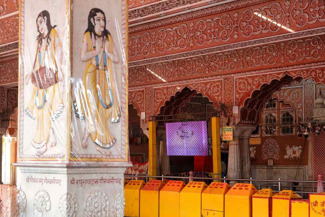 Interno del Tempio di Govind Dev, con un pilastro con dipinte figure femminili in una grande sala.
