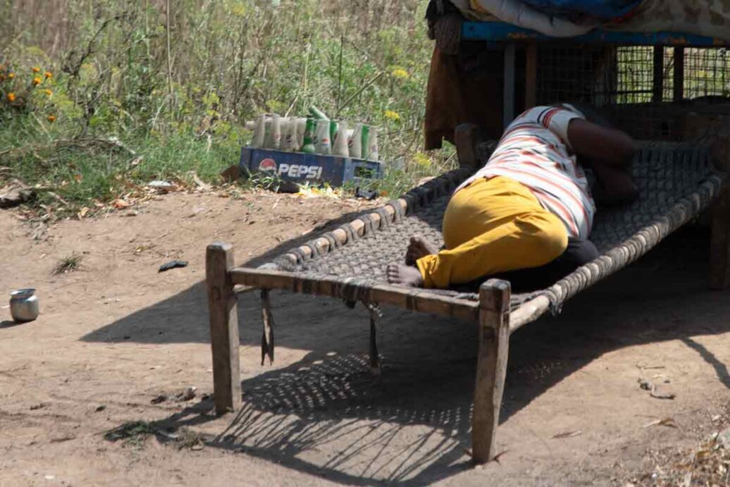Uomo dorme su una branda Un uomo dorme su una vecchia branda per strada in India.