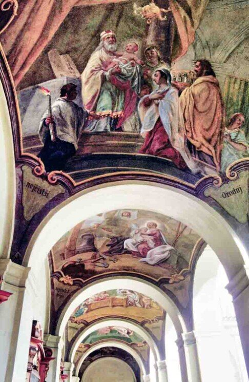 Porticato affrescato del Santuario di Loreto a Praga con scene bibliche dipinte sulle volte e archi del chiostro barocco.